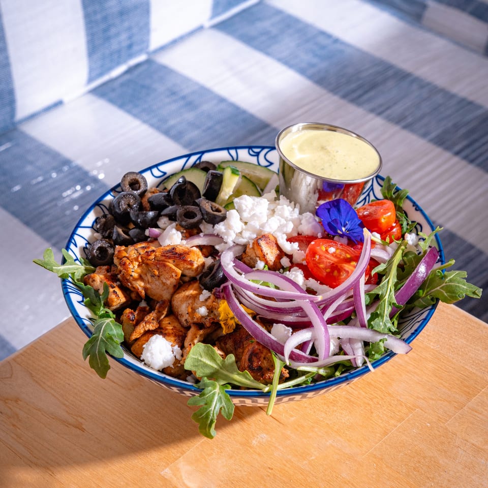 A Lo Fresco's healthy chicken salad with olives, feta, tomatoes, onions, and dressing.